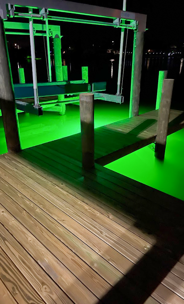 A dock area with green colored underwater light.