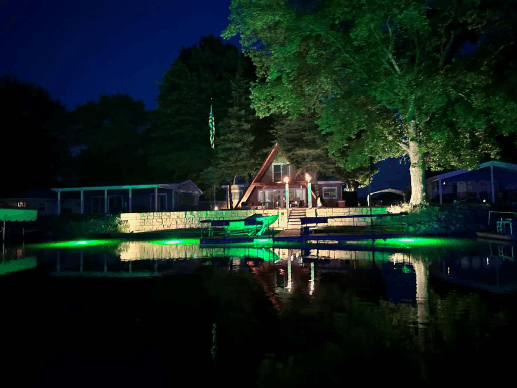 A green colored underwater LED light shining at night. 