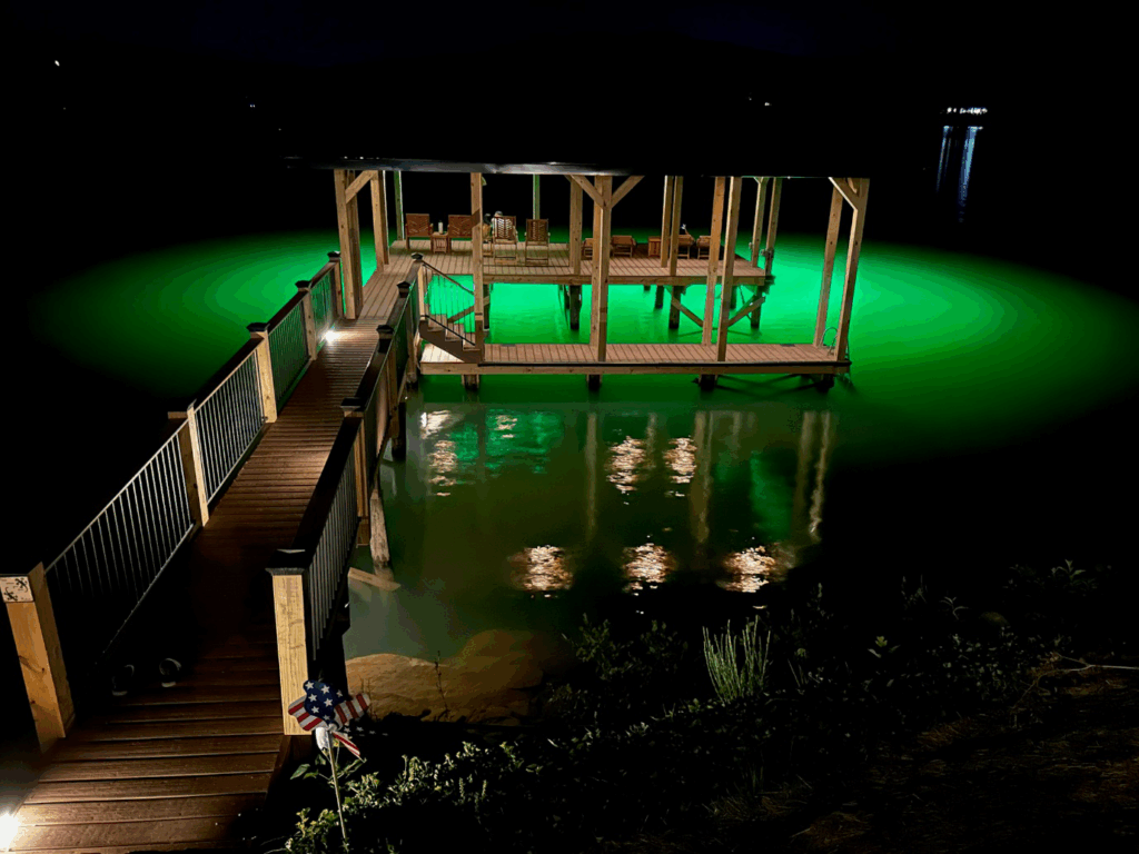A dock illuminated by underwater green lights