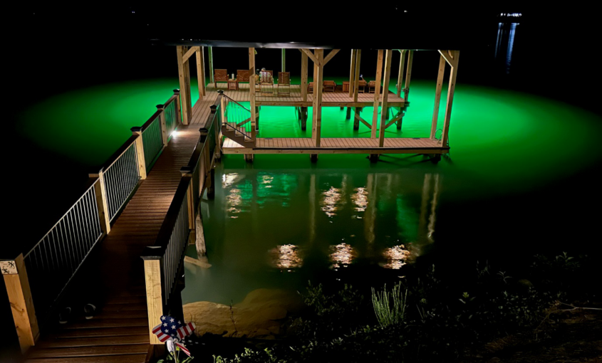 A dock illuminated by underwater green light