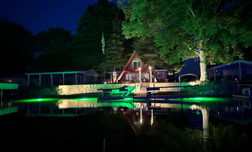 A green colored underwater LED light shining at night.