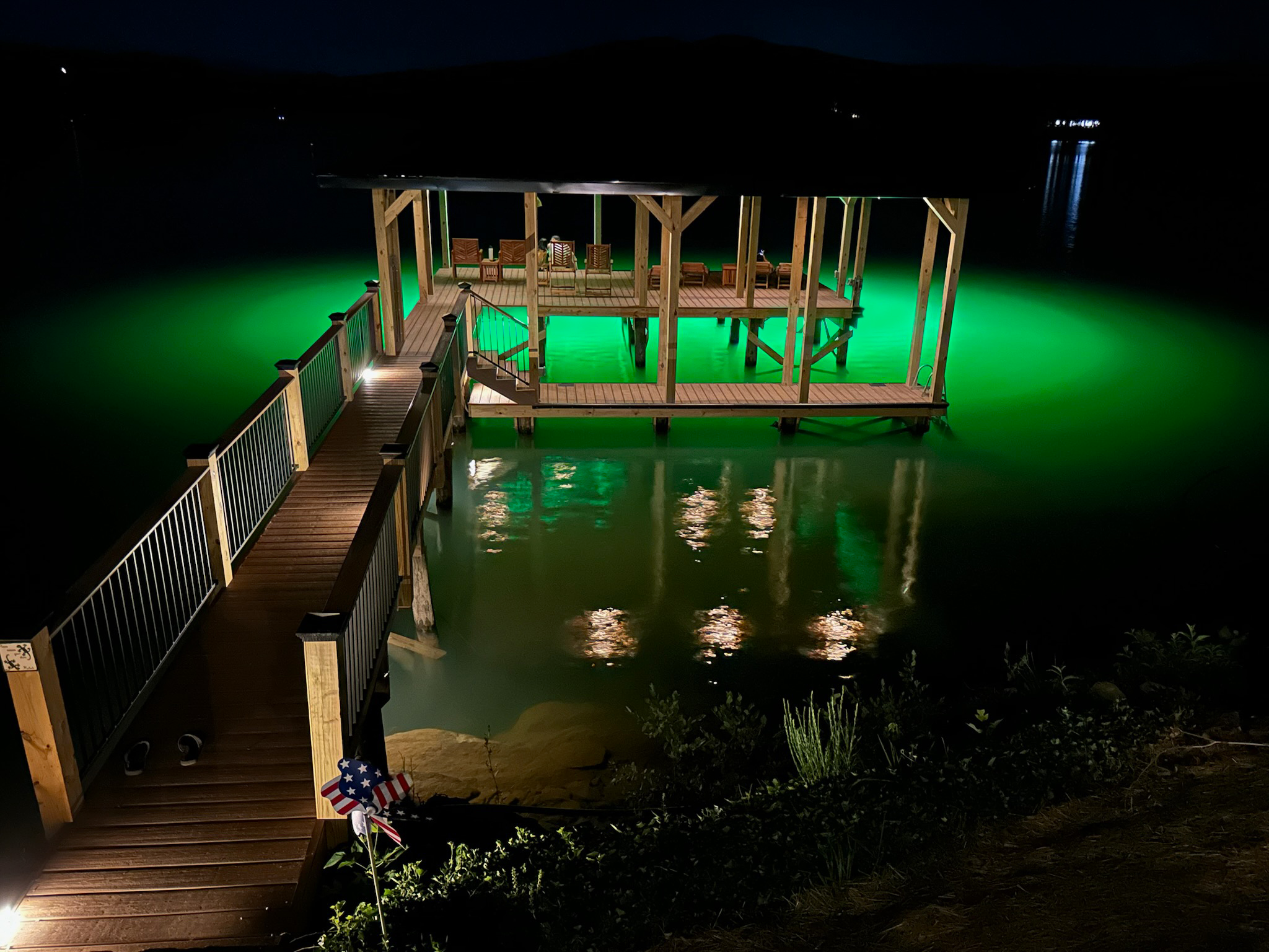 green underwater dock lights illuminating the fishing area beneath the waterfront dock at night