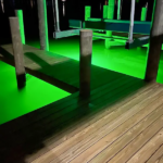 Green light illuminated in the water under the docks