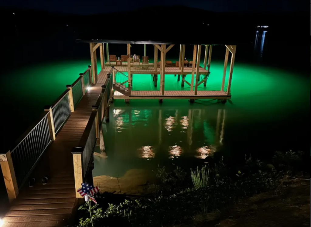 A green colored underwater LED light under the bridge. 