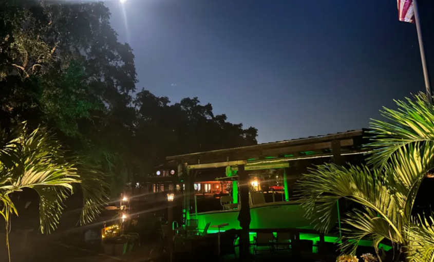 A large waterfront property with green underwater LED Lights.