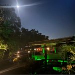 A large waterfront property with green underwater LED lights.