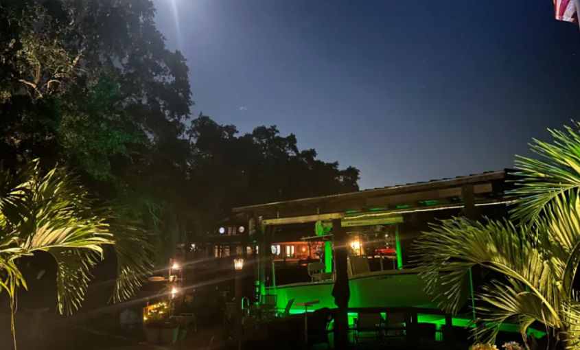 A large waterfront property with green underwater LED lights.