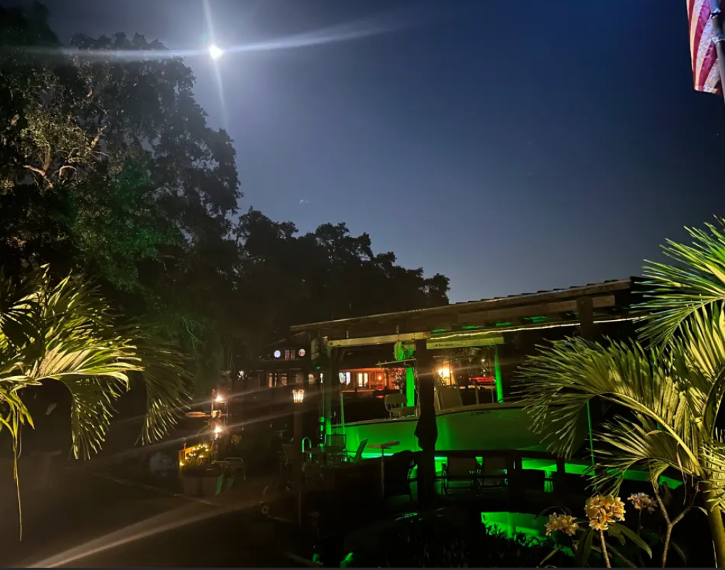 A large waterfront property with green underwater LED lights.