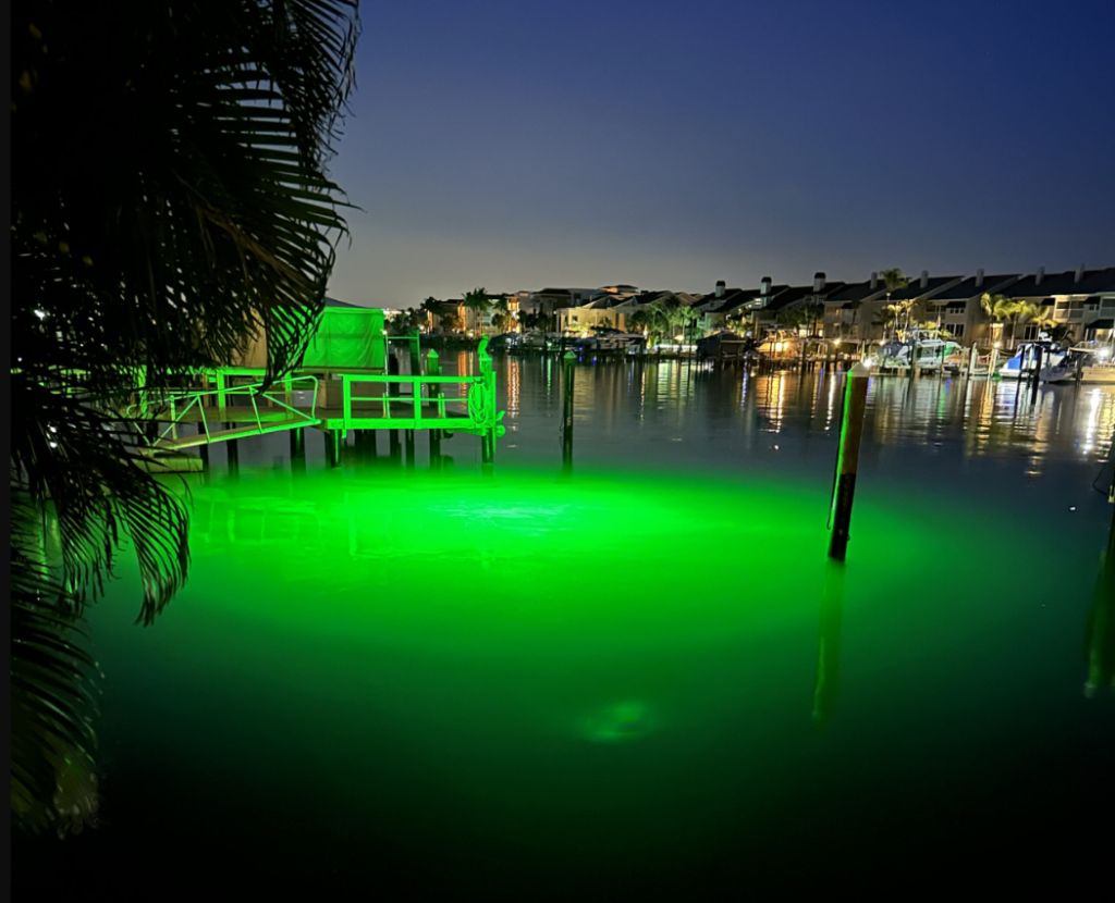 A dock area with a green underwater LED light. 