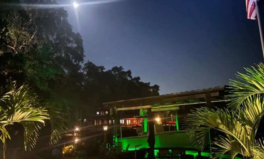 A green colored underwater LED light placed at a seaside property.