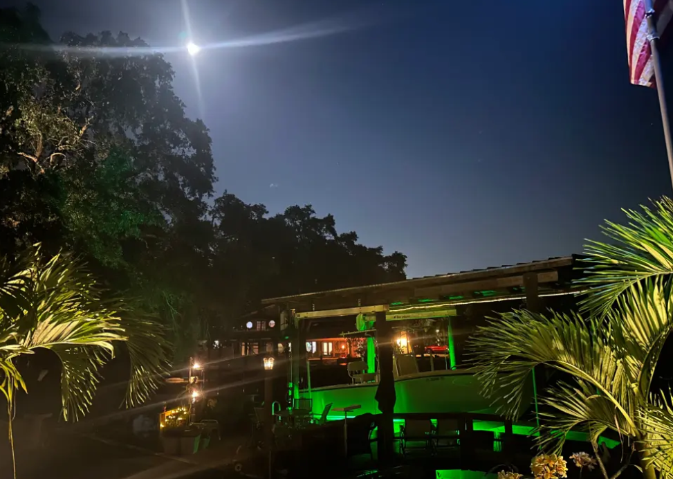 A green colored underwater LED light placed at a seaside property.